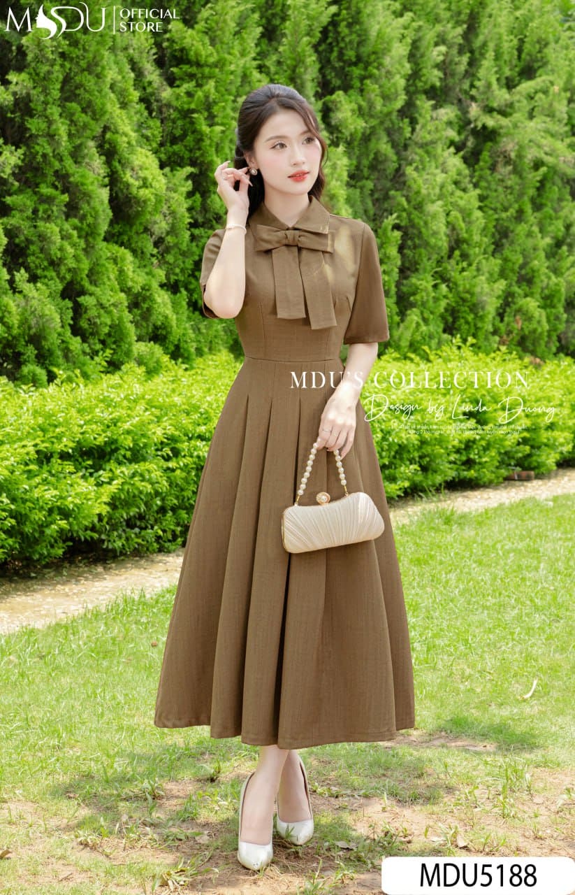 Váy Thiết Kế MDU5188 Xước Thái Nâu Dáng Xòe Dài Cổ Bẻ Nơ To Xếp Ly Tôn Dáng 19 Váy Thiết Kế MDU5188 Xước Thái Nâu Dáng Xòe Dài Cổ Bẻ Nơ To Xếp Ly Tôn Dáng