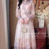 Váy Thiết Kế MDU6610 – Tơ Hàn Nền Kem Hoa Pastel, Cổ Sơ Mi Phối Đai Eo Thanh Lịch 1 Model in outfit pearl bag 202607251443 1 11zon Mdu Fashion